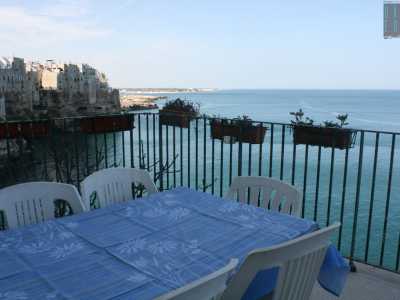 Al centro del balcone spicca un grande tavolo con una tovaglia celeste. Anche se non � certo questo oggetto ad attrarre la nostra attenzionema ma il panorama che si svela davanti ai nostri occhi. A sinistra e a destra � la scogliera a fare da padrona con la sua alta costa frastagliata